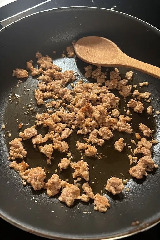 Ground turkey browning in skillet for easy ground turkey stuffed peppers