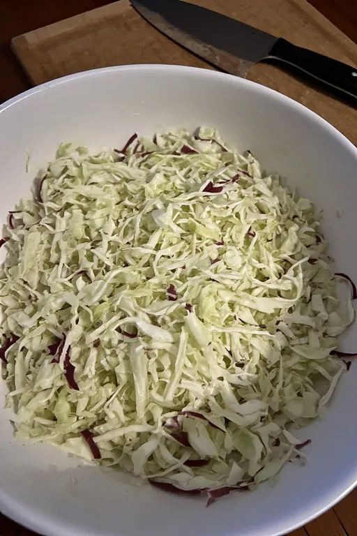 finely shredded green and red cabbage on a cutting board