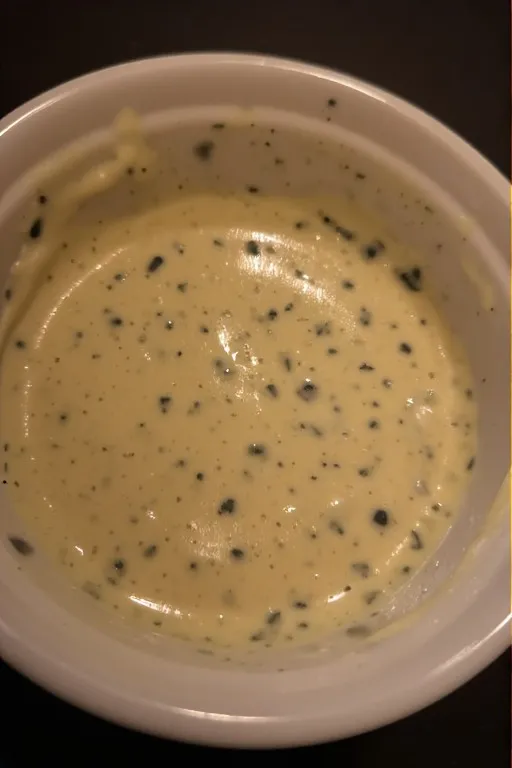 whisking honey dijon dressing in a small bowl