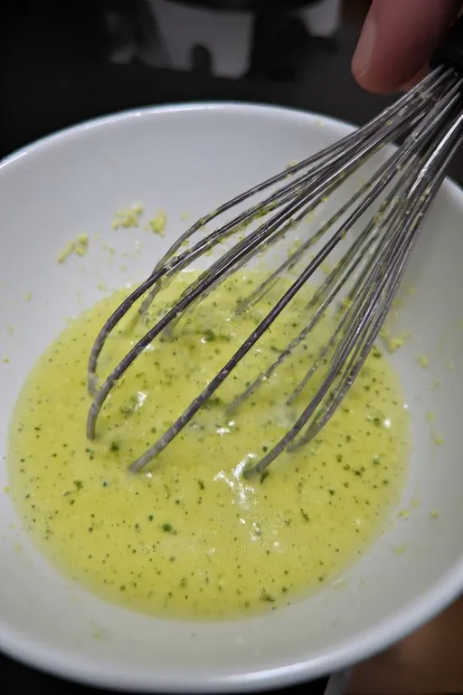Whisking a yellow-green mixture in bowl