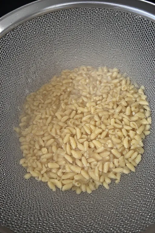 Orzo pasta draining in a colander for easy orzo pasta salad recipe