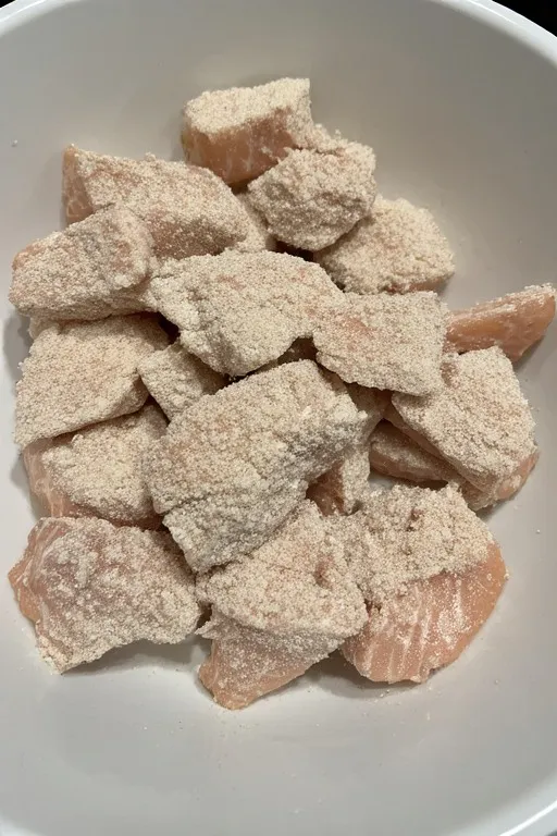 Salmon chunks coated in seasoned cornstarch for pan frying