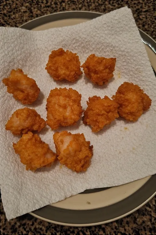 Crispy golden salmon bites draining on paper towels