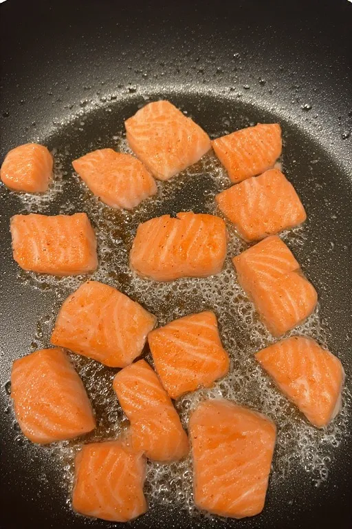 Pan frying salmon bites until crispy and golden brown