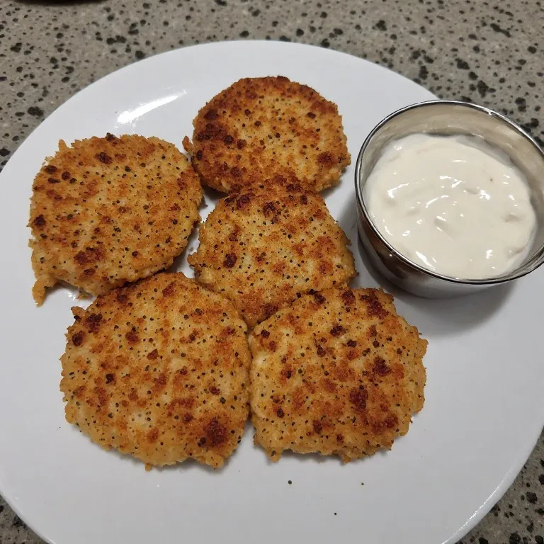 Crispy golden canned salmon patties draining on paper towel after pan frying