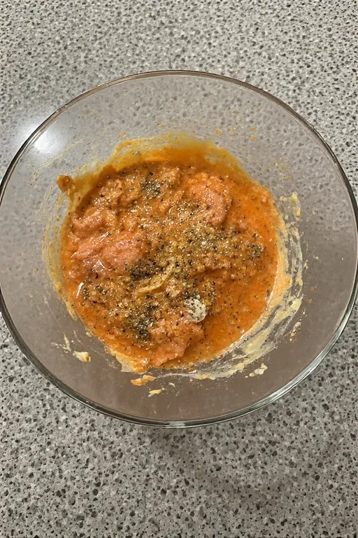 Canned salmon patty mixture with egg and seasonings in bowl