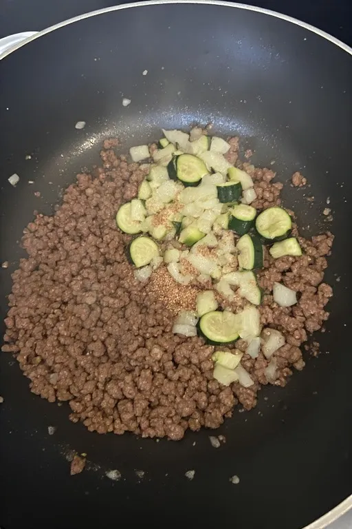 Onion garlic and zucchini flesh added to ground beef for keto zucchini boats filling