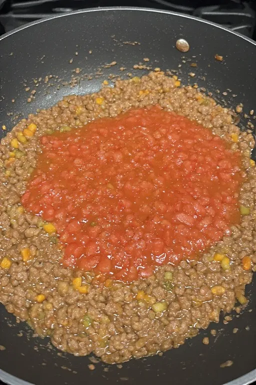 Tomatoes and Worcestershire sauce added to beef filling for keto stuffed zucchini boats