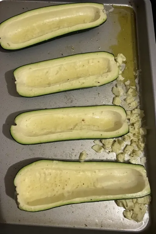 Hollowed zucchini halves on baking sheet prepped for keto zucchini boats recipe
