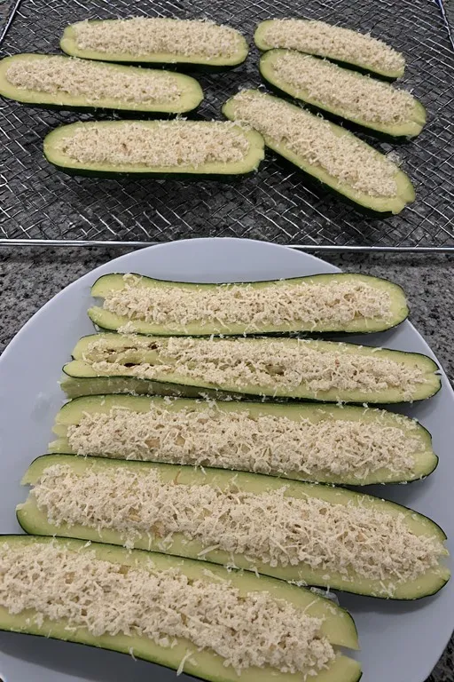 Zucchini fries being coated in almond flour and Parmesan for keto recipe