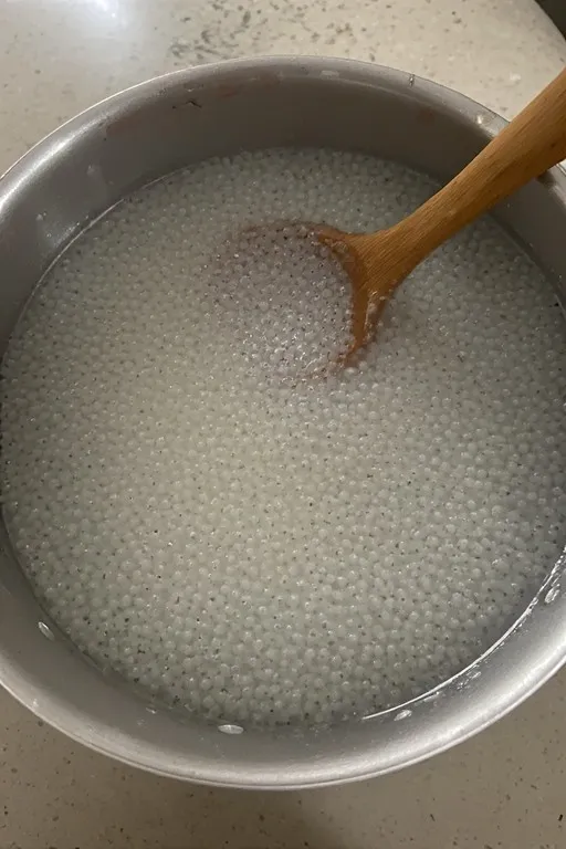 Small pearl tapioca cooking in boiling water for mango sago dessert recipe