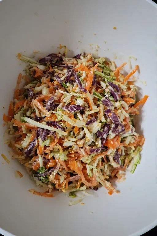  Mixed mango slaw with cabbage and lime dressing in large bowl