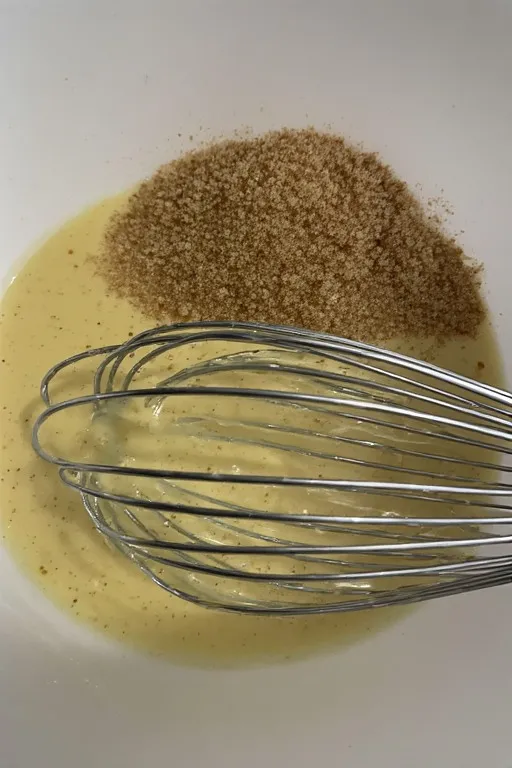 Wet ingredients whisked together in bowl for zucchini muffins batter