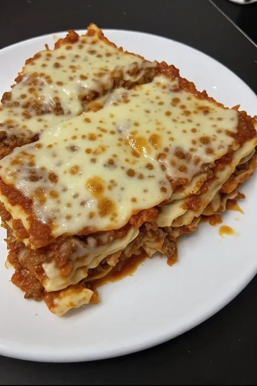 Perfect slice of best lasagna recipe showing layers of meat sauce ricotta and melted cheese