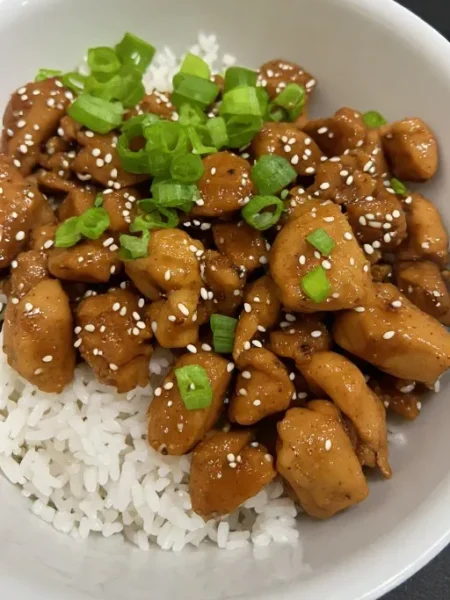 Dump and go crockpot teriyaki chicken served over rice with sesame seeds and green onions