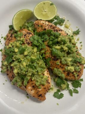 Fiesta lime chicken with avocado salsa and cilantro on plate ready to serve