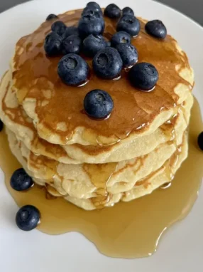 Fluffy pancake recipe with fresh blueberries and maple syrup on a plate