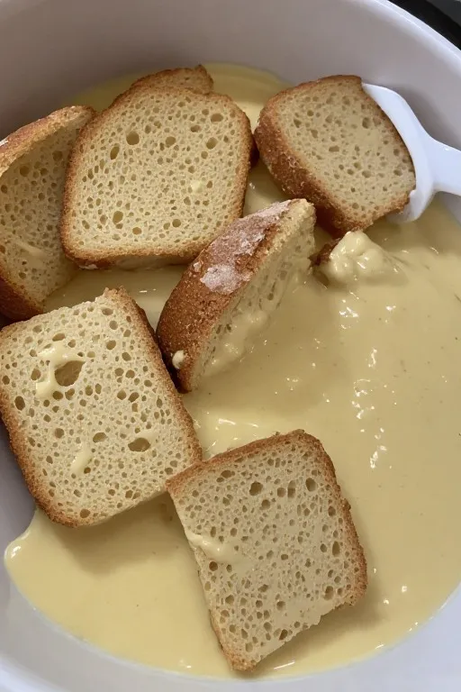 Thick brioche bread slices soaking in custard mixture for best French toast recipe