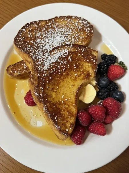 Best French toast recipe served on plate with butter powdered sugar and fresh berries for perfect breakfast