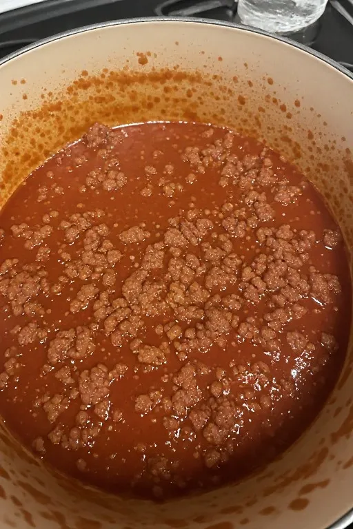 Homemade meat sauce simmering in pot for best lasagna recipe