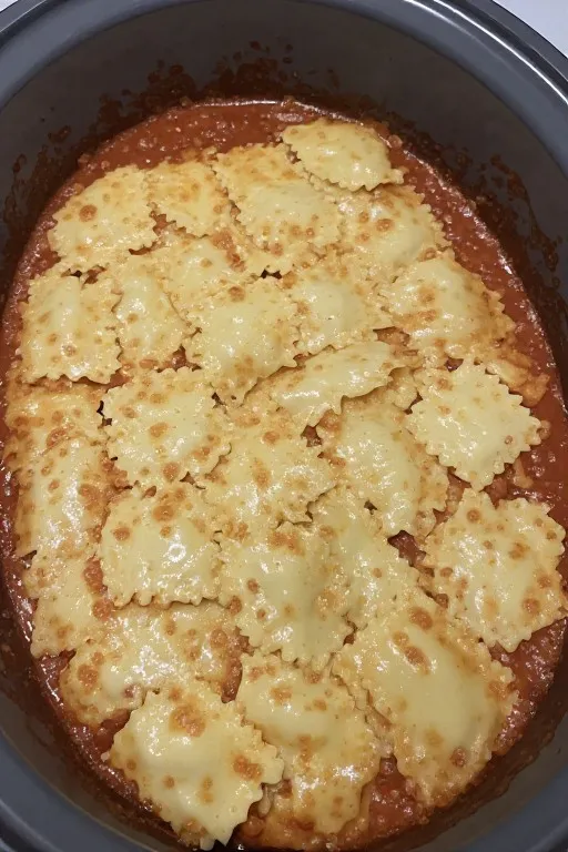 Finished crockpot ravioli lasagna in slow cooker with melted cheese on top