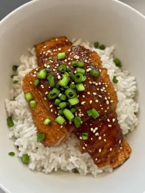 Salmon teriyaki recipe final served over rice with green onions and sesame seeds