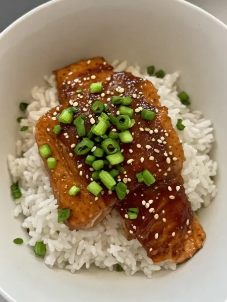 Salmon teriyaki recipe final served over rice with green onions and sesame seeds