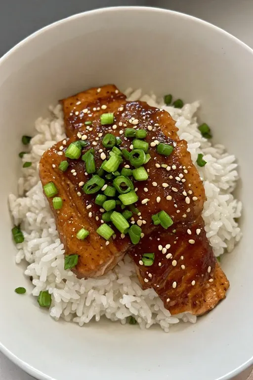 Salmon teriyaki recipe final served over rice with green onions and sesame seeds