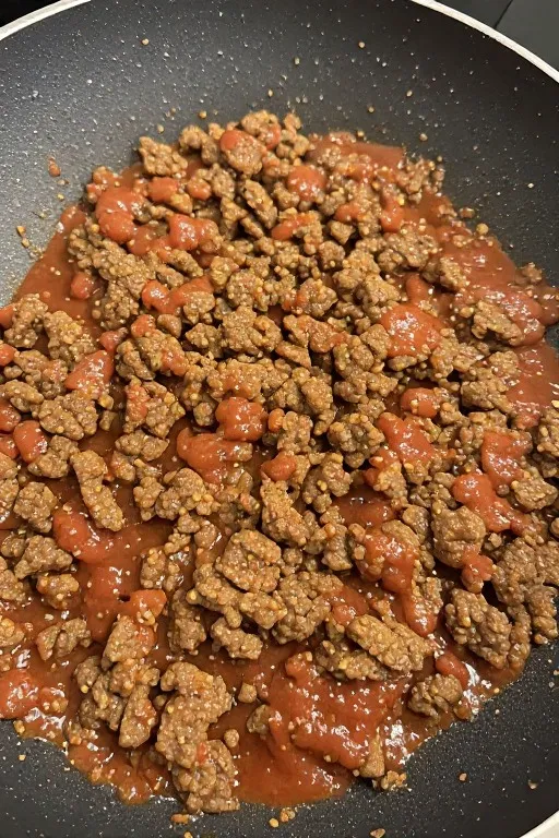 Seasoned taco beef cooking in skillet for taco salad recipe