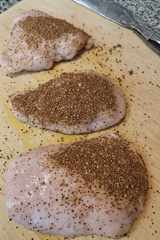 Chicken breasts coated with spice rub before going into the air fryer