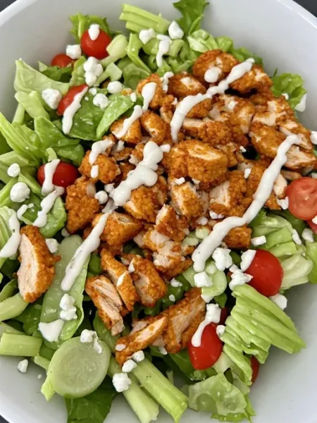 Buffalo chicken salad with crispy buffalo chicken blue cheese and ranch dressing in bowl