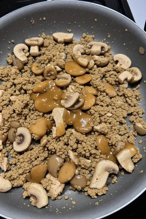 Ground chicken and mushrooms cooking in skillet for chicken lettuce wraps recipe