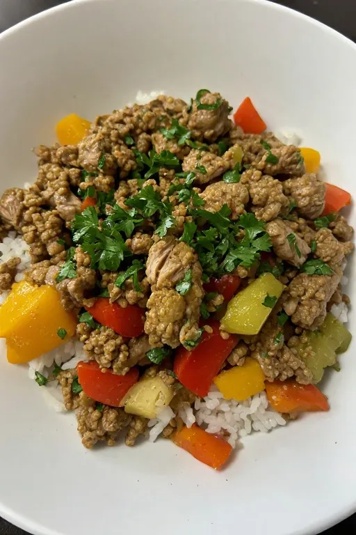 Ground turkey skillet served in white bowl over rice with fresh parsley