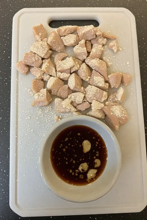 Cornstarch coated chicken pieces and stir fry sauce ingredients before cooking