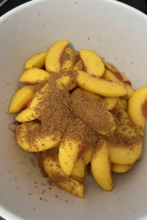 Sliced peaches mixed with sugar cinnamon and lemon before baking