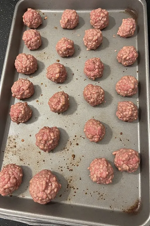 Raw turkey meatballs on baking sheet before baking for turkey meatball recipe
