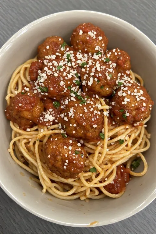 Turkey meatballs served over spaghetti with marinara sauce and fresh basil