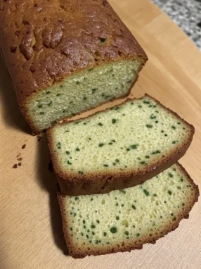 Zucchini bread recipe sliced on cutting board showing moist interior with green zucchini specks