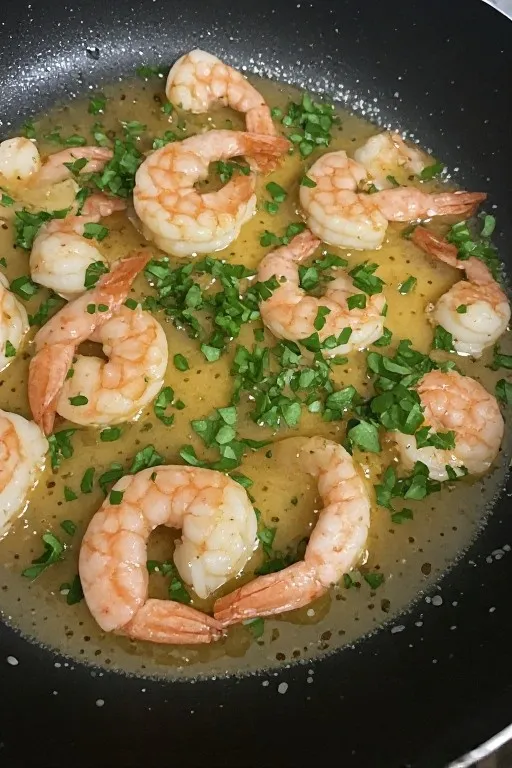 Garlic butter shrimp served over rice with parsley and lemon